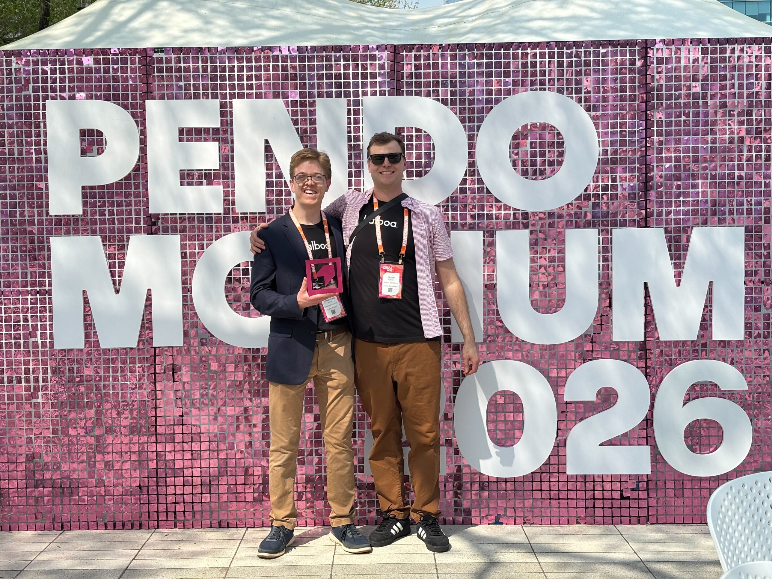 Two Balboa teammates in front of the Pendomonium 2026 sign, one holding an award